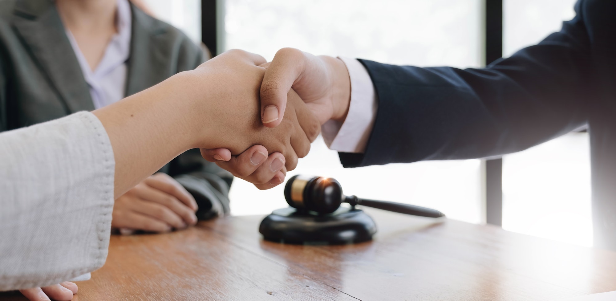 Businessman shaking hands to seal a deal with his partner lawyers or attorneys discussing a contract